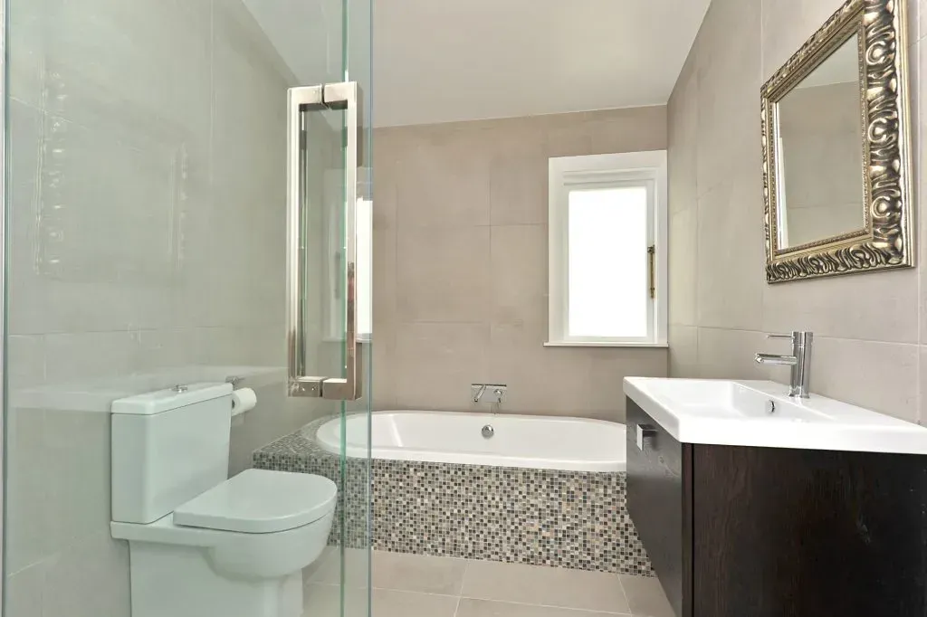 Completed bathroom renovation with a freestanding bath and tiled walls