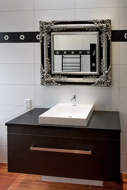Bathroom renovation with a dark vanity and stone benchtop