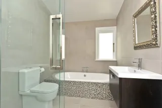 Bathroom with freestanding tub, mosaic tile accent and wall-hung vanity