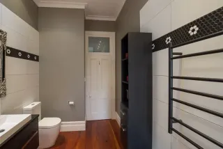 Modern bathroom with white wall tiles, black vanity and heated towel rail