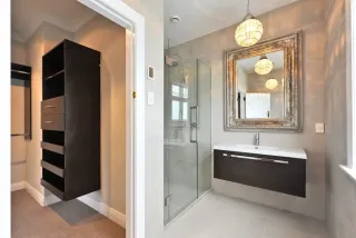 Master bathroom with black vanity, glass shower and walk-in closet