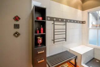 Bright bathroom with white tiles, built-in storage and decorative accents