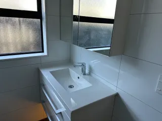 Modern bathroom vanity with white vessel sink and large framed mirror