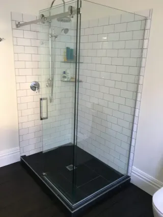 Walk-in shower with white subway tile and frameless glass enclosure