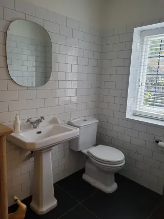 Classic pedestal sink bathroom with white subway tiles and chrome fixtures